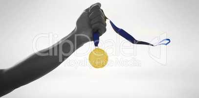 Hand holding a gold medal on white background