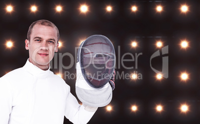 Composite image of swordsman holding fencing mask