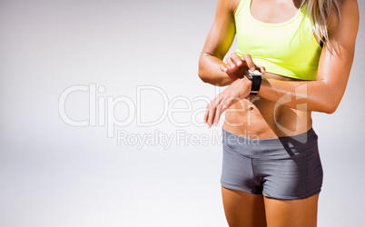 Composite image of sporty woman looking her watch