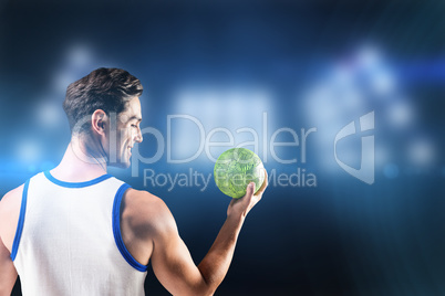 Composite image of happy athlete male holding a ball