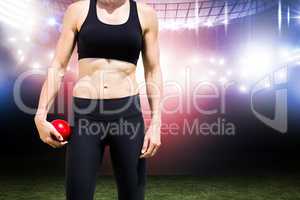 Composite image of sporty woman holding a red ball