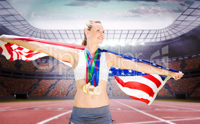 Composite image of portrait of happy sportswoman with medals hol