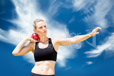 Composite image of front view of sportswoman practising shot put