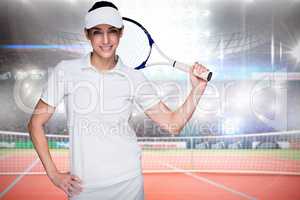 Composite image of sportswoman posing with a tennis racket