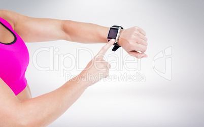 Composite image of female athlete using her smart watch Composite image of female athlete using her smart watch