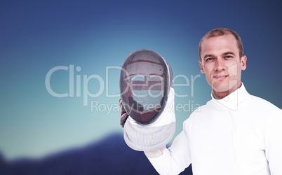 Composite image of swordsman holding fencing mask