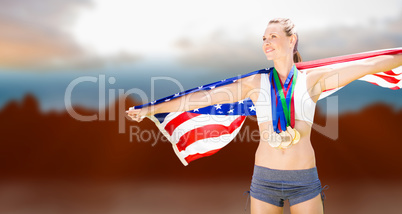 Composite image of portrait of happy sportswoman with medals hol