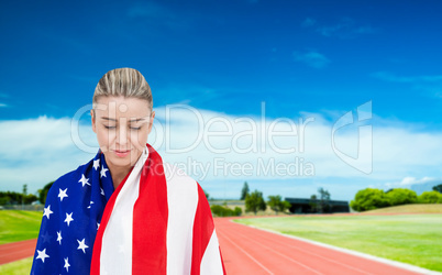 Female athlete with american flag on her shoulders on a sunny da