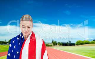 Female athlete with american flag on her shoulders on a sunny da