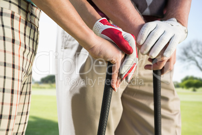 Composite image of hands holding golf club Composite image of hands holding golf club