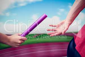 Athlete passing a baton to the partner