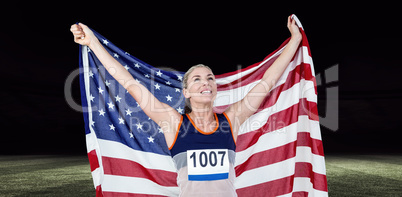 Composite image of athlete posing with american flag after victo