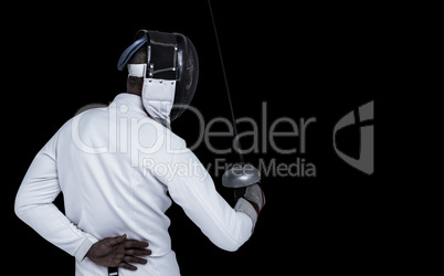 Composite image of man wearing fencing suit practicing with swor