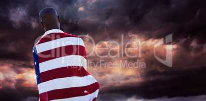 Composite image of rear view of man wearing american flag