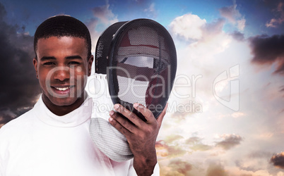 Composite image of swordsman holding fencing mask