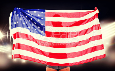 Composite image of athlete posing with american flag after victo