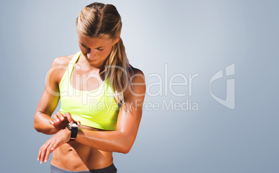 Composite image of sporty woman looking her watch