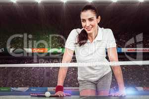 Composite image of female athlete leaning on ping pong table