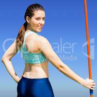 Composite image of rear view of sporty woman holding a javelin