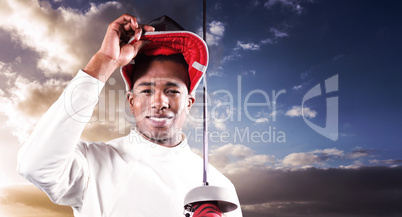 Composite image of portrait of swordsman standing with fencing m