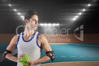 Composite image of confident athlete man holding a ball