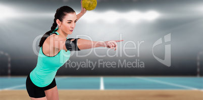 Composite image of female athlete with elbow pad throwing handba