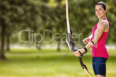 Composite image of sportswoman practicing archery