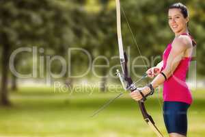 Composite image of sportswoman practicing archery