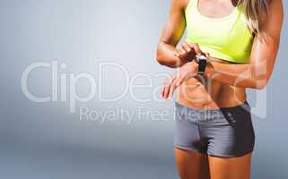 Composite image of sporty woman looking her watch