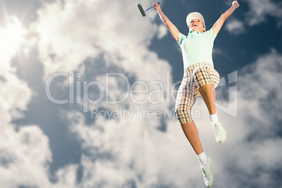 Woman jumping with golf club