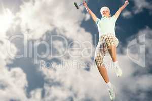 Woman jumping with golf club