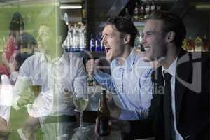 Composite image of handsome friends having a drink together