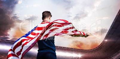 Composite image of rear view of sportsman holding an american fl