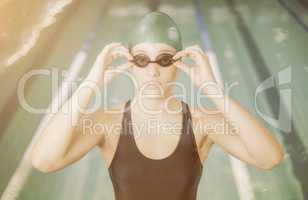 Woman in swimsuit adjusting her goggles