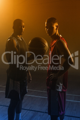 Two basketball player holding a single basketball