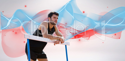 Composite image of athletic man pressed on a hurdle posing