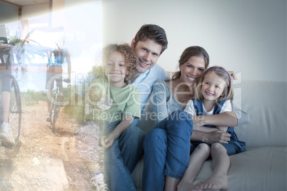 Composite image of smiling family watching tv together