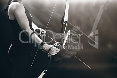 Composite image of sportswoman practicing archery