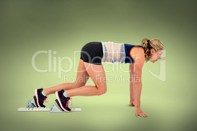 Composite image of female athlete on starting blocks