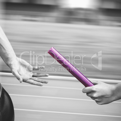 Composite image of athlete passing a baton to the partner