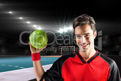 Composite image of portrait of happy athlete man holding a ball