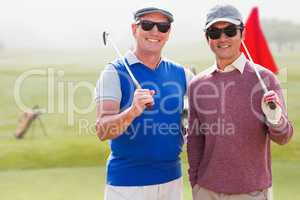 Composite image of men holding golf club