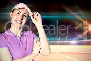 Sportswoman posing with touching cap