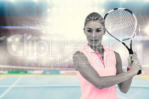 Composite image of sportswoman posing with a tennis racket