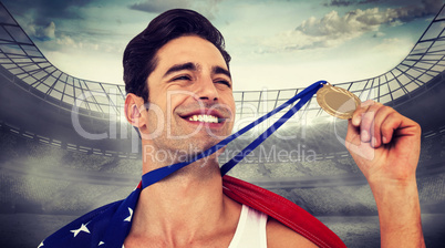 Composite image of athlete holding gold medal after victory