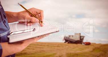 Composite image of cropped image of businessman writing with pen