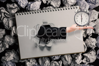 Composite image of hand holding alarm clock