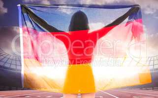 Composite image of athlete posing with german flag after victory