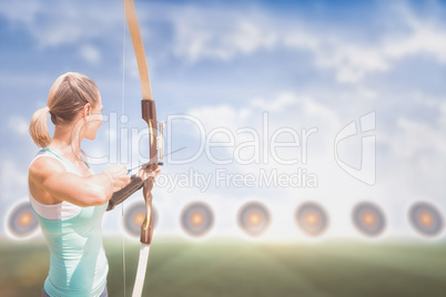 Rear view of sportswoman practicing archery