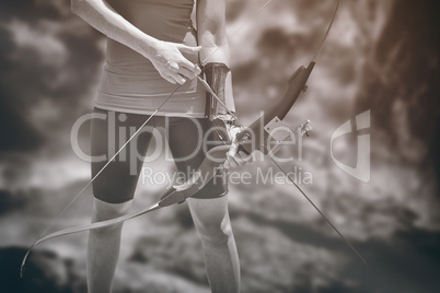 Composite image of focus on sportswoman holding an arch